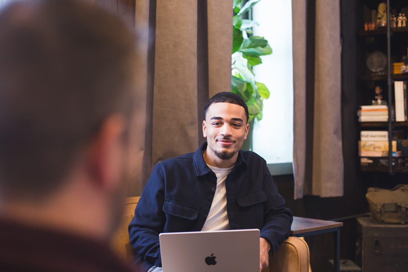 Jaedon working on a laptop in a cafe meeting
